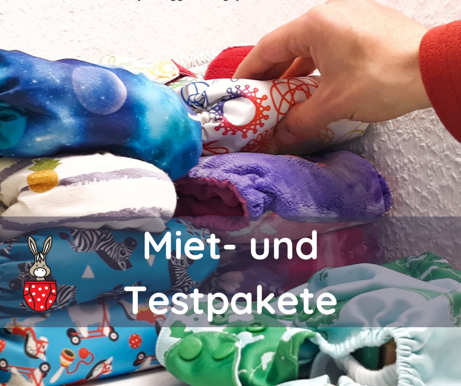 Eine Hand greift eine Stoffwindel, die auf einer Stapel ist.